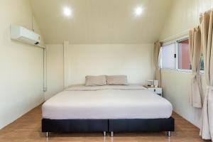 a bedroom with a white bed in a room at PATTA Hideaway Chiang Dao in Chiang Dao