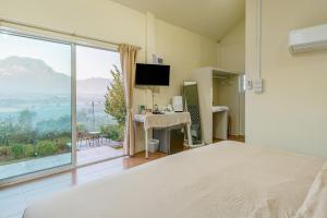 a bedroom with a bed and a large window at PATTA Hideaway Chiang Dao in Chiang Dao