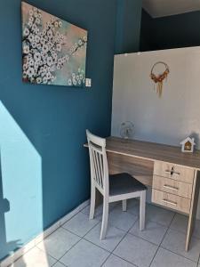 biurko z krzesłem i obrazem na ścianie w obiekcie Valentino's Apartment w mieście Panormos Kalymnos