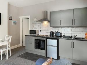 a kitchen with white cabinets and a stove top oven at Rose - Uk49363 in Bridlington