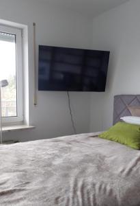 a bedroom with a flat screen tv on the wall at Apartment Kliniknähe in Idar-Oberstein