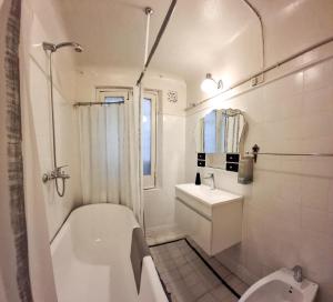 a bathroom with a tub and a toilet and a sink at LOPEZ Hostel & Suites in Buenos Aires +84 photos