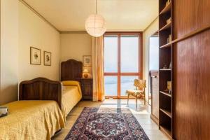 a bedroom with a bed and a large window at Villa Bellavista Lakeview Pool in Civenna +33 photos