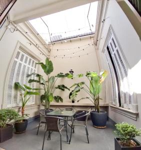 a patio with a table and chairs and plants at LOPEZ Hostel & Suites in Buenos Aires