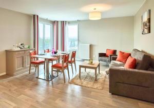 a living room with a couch and a table at Zenao Appart'hôtels Suresnes in Suresnes
