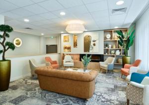 a waiting room with a couch and chairs at Zenao Appart'hôtels Suresnes in Suresnes