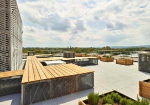 a rooftop patio with tables and benches on a building at Zenao Appart'hôtels Suresnes in Suresnes +7 photos
