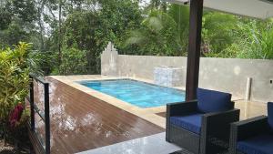 a swimming pool on a deck with two chairs at Oro Verde Lodge in Fortuna