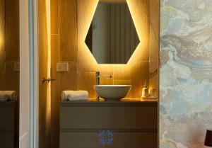 a bathroom with a sink and a mirror at Passo Lento Charme Rooms in Gravina in Puglia +16 photos