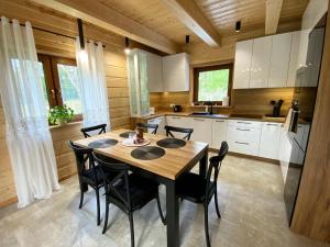 a kitchen with a wooden table and black chairs at Radość o poranku in Smardzew