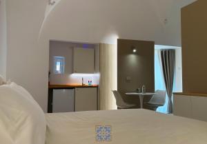 a bedroom with a bed and a kitchen and a table at Passo Lento Charme Rooms in Gravina in Puglia