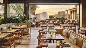 a restaurant with tables and chairs on a patio at Conrad Los Angeles in Los Angeles