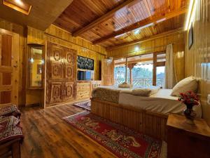 ein Schlafzimmer mit einem Bett in einer Holzhütte in der Unterkunft Cafe Saffron Sips & Stays - Alpine Suites Naggar Near Manali in Nagar