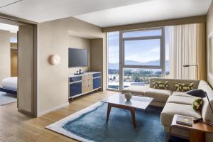 a living room with a couch and a tv at Conrad Los Angeles in Los Angeles