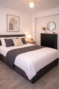 a bedroom with a large bed and a mirror at EMGS property ltd in Liverpool