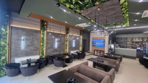 a restaurant with couches and tables and a bar at Pensiunea Casa Mitus in Strehaia