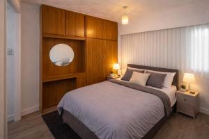 a bedroom with a large bed with a wooden wall at EMGS property ltd in Liverpool