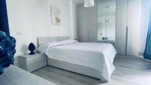 a white bedroom with a bed and a mirror at Agape in Policoro