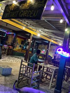 a man sitting at a table in front of a restaurant at elephant garden in Ban Bang Bao