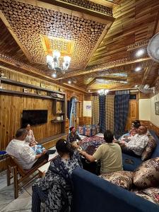 eine Gruppe von Menschen, die in einem Raum sitzen in der Unterkunft Cafe Saffron Sips & Stays - Alpine Suites Naggar Near Manali in Nagar