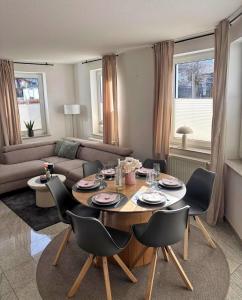 a living room with a table with chairs and a couch at Upland-Living in Willingen +19 photos