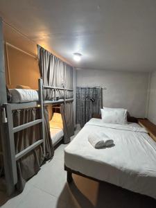 a bedroom with a bed and two bunk beds at Sleep Squad Hostel in El Nido