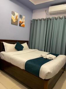 a bedroom with a bed with a green curtain at Umai Garden Resort in Jogīkuti +2 photos
