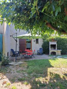 a patio with a table and chairs and an umbrella at L'oustalet du Luberon in Cadenet +8 photos