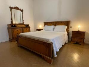 a bedroom with a large wooden bed with a mirror at A Casa di Luca in Faenza