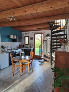 a kitchen with a table and chairs and a staircase at L'oustalet du Luberon in Cadenet