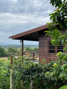 a wooden cabin with a fence in front of it at PATTA Hideaway Chiang Dao in Chiang Dao
