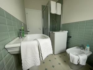 a bathroom with a tub and a toilet and towels at A Casa di Luca in Faenza