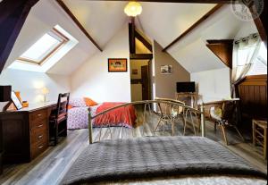 a attic bedroom with a bed and a desk at Ferme de la Forterie Verlinghem in Verlinghem