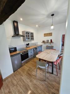 a kitchen with a wooden table and chairs in it at Gite Le Reposoir Argoules in Argoules +9 photos