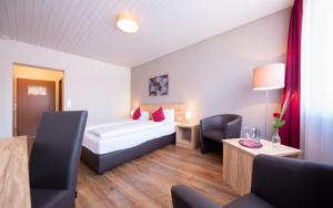 a hotel room with a bed and a table and chairs at Hotel Restaurant Haus Waldesruh in Eppenbrunn