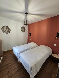 two beds in a room with red walls at Gite Le Reposoir Argoules in Argoules