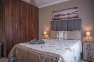 a bedroom with a large bed with a teddy bear on it at Rusty Estate - Self Catering in eMalahleni