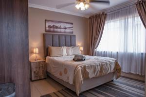 a bedroom with a large bed and a window at Rusty Estate - Self Catering in eMalahleni