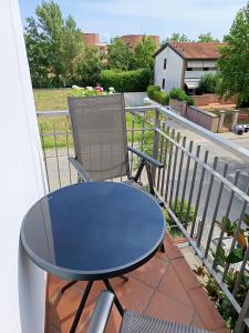 a blue table and a chair on a balcony at A Casa di Luca in Faenza