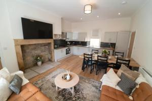 a living room with a couch and a table and a kitchen at Foundry Farm Apartment in Hexham