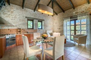 a kitchen and dining room with a table and chairs at San Antonio Villas in Pandokrátor