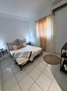 a bedroom with a bed and a tiled floor at Villa lina in Midoun