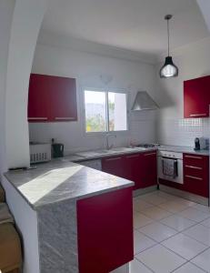 a kitchen with red cabinets and a counter top at Villa lina in Midoun