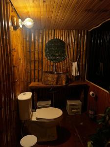 a bathroom with a toilet and a wooden wall at Glamping Villa JuanMa in Salónica
