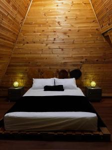 a bedroom with a large bed with wooden walls at Glamping Villa JuanMa in Salónica
