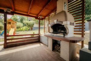 a outdoor pizza oven with a view of a playground at Forest by Leni - National Park Salt Pool Villa in Beočin