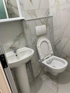 a white bathroom with a toilet and a sink at Vila Palma in Draç