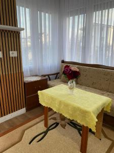 a living room with a table with a vase of flowers on it at Vila Palma in Draç