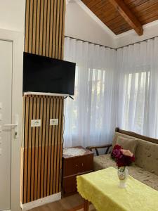 a living room with a table and a television at Vila Palma in Draç