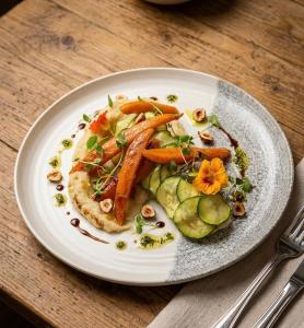 a plate of food with carrots and vegetables on a table at Hotel Carina-Très Grande Piscine-Local à Vélo in Apt